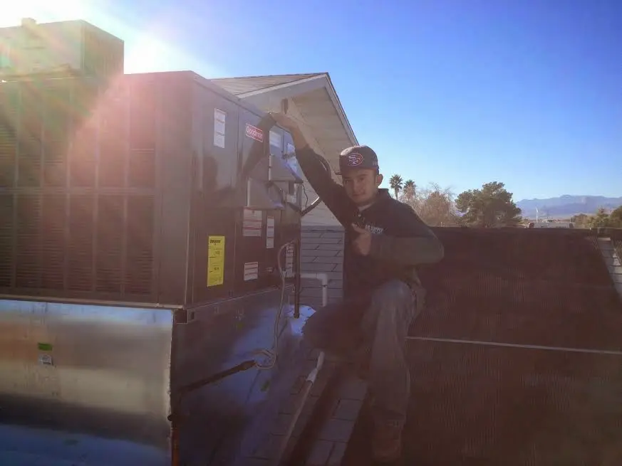 HVAC technician performing AC Tune-Up on a rooftop unit in Webster Groves